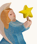 A close up of the blur Ostheimer wooden angel figure holding a star, available at Babipur showing the hand painted detail