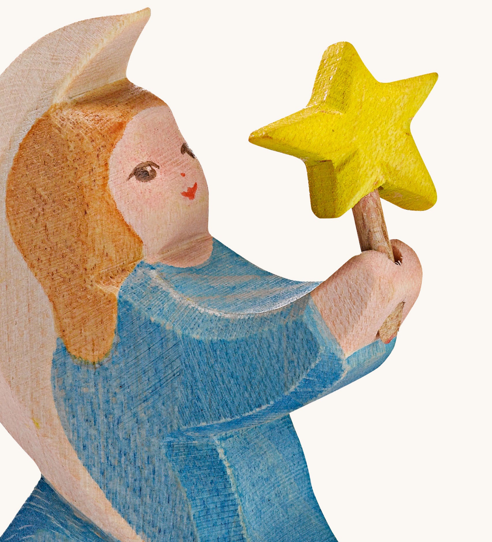 A close up of the blur Ostheimer wooden angel figure holding a star, available at Babipur showing the hand painted detail