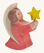 A Ostheimer wooden angel figure holding a star, available at Babipur. This handmade and hand painted festive figure has a rose pink dress and brown hair holding a yellow star