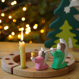 Grimm's Wooden Celebration Ring with Osthiemer Angels, pink with star and green with flute, Christmas rocking figures for sale at Babipur.
