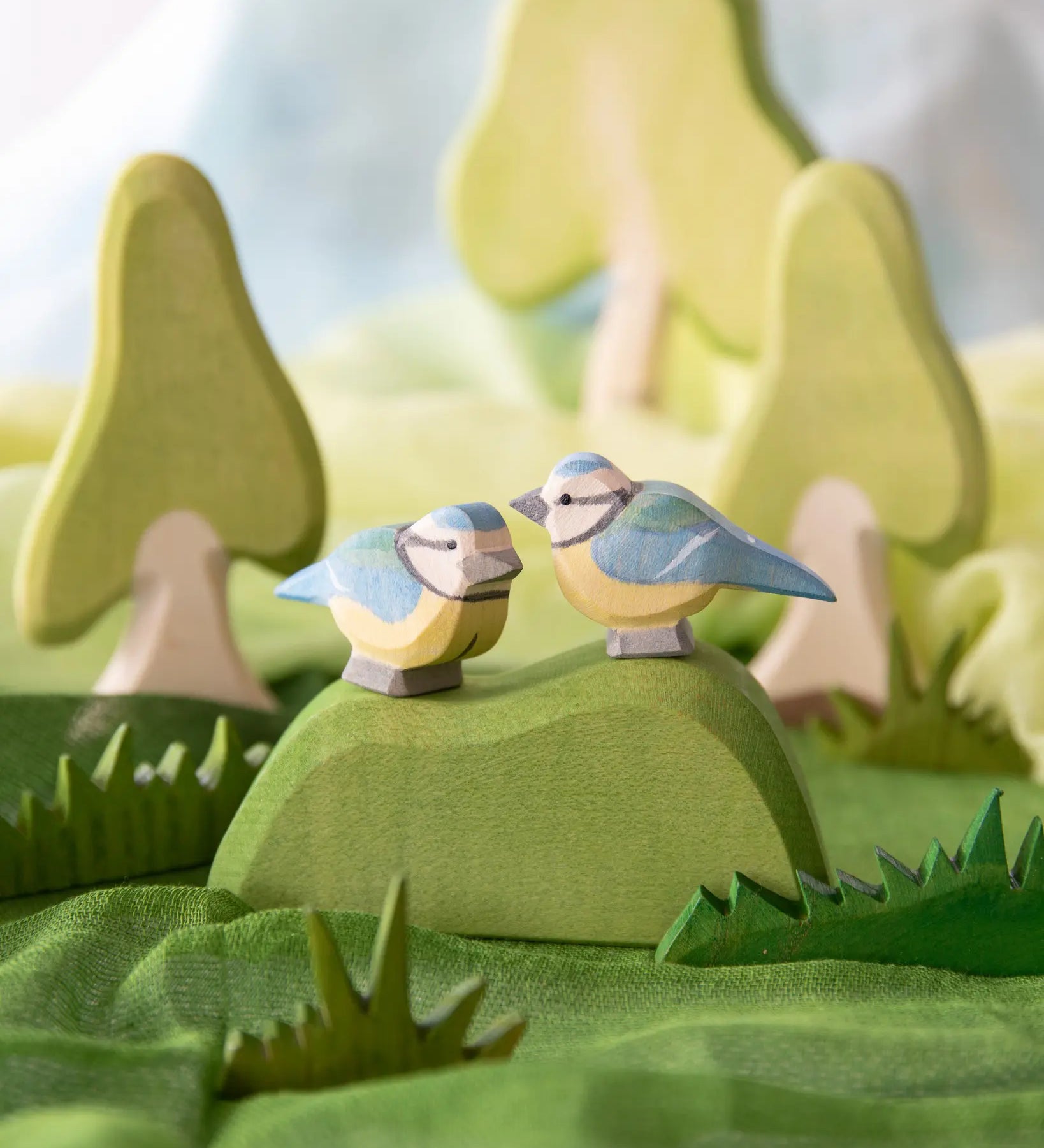 Ostheimer blue tits, wooden bird toys in small world play scene using Ostheimer trees, scarves and grass.