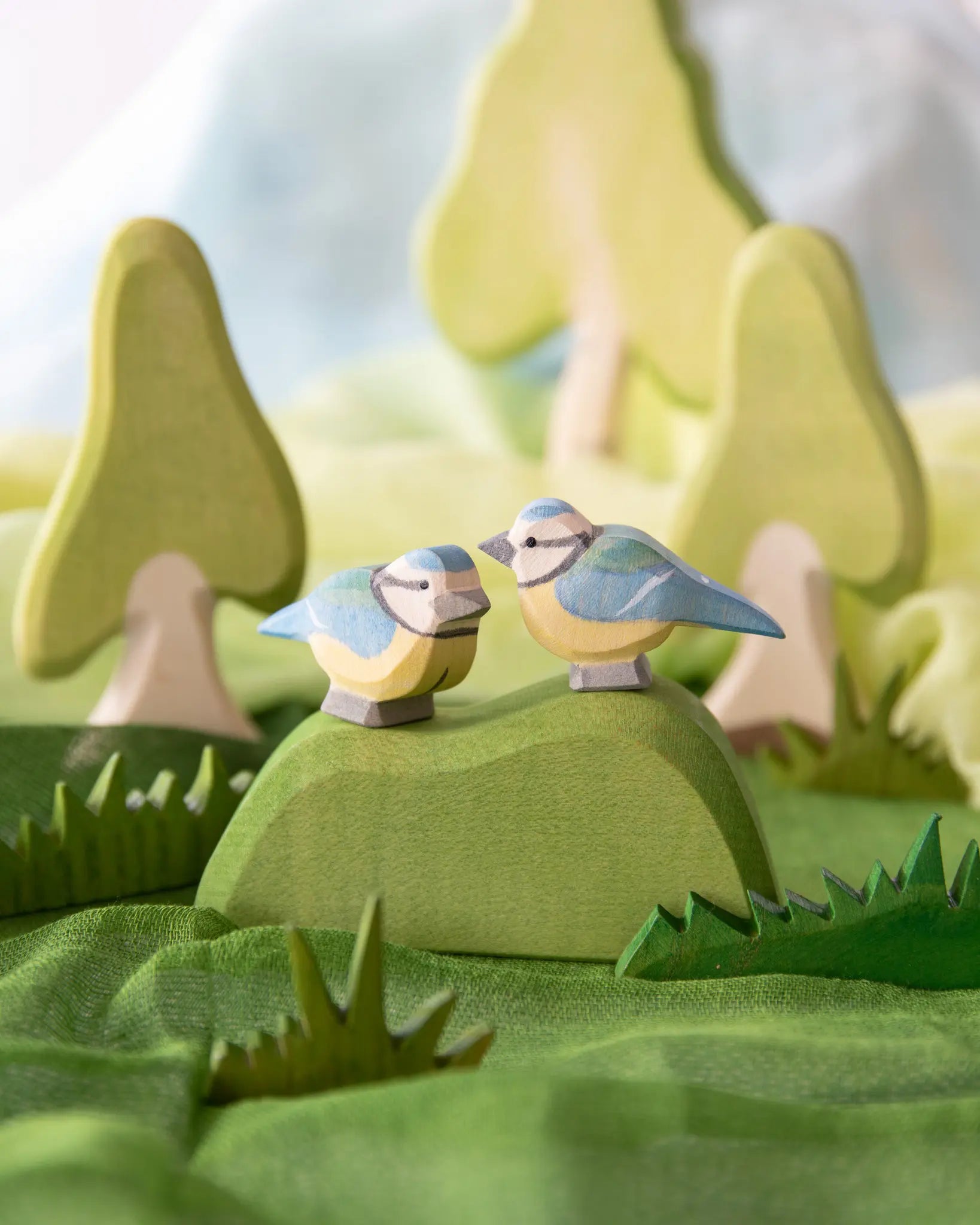 Ostheimer blue tits, wooden bird toys in small world play scene using Ostheimer trees, scarves and grass.