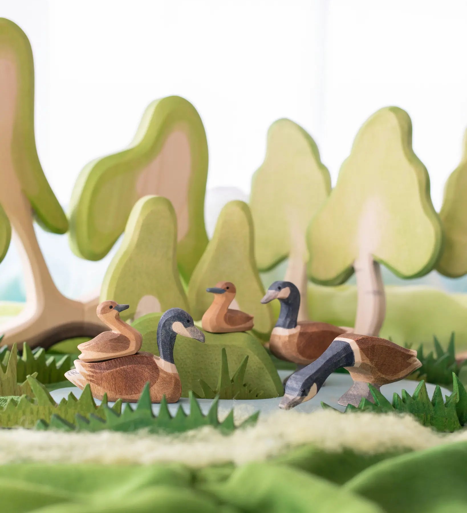 Ostheimer Canada Goose family. Wooden toys in small world play scene using trees, scarves and grass by Ostheimer.
