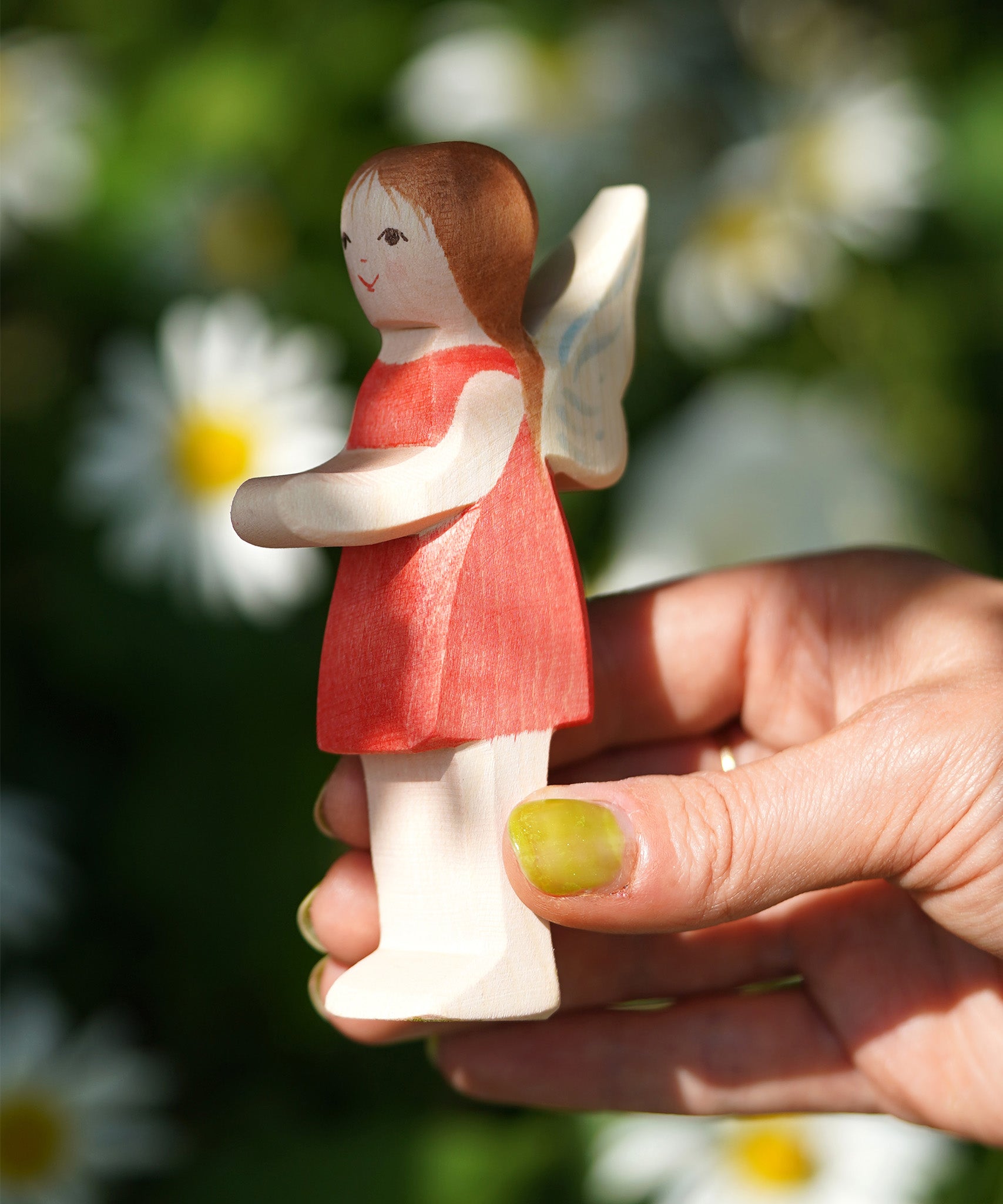 An adult hand holding the Ostheimer wooden 'Sumselinchen' character figure from the German story “Pepe and Sumselinchen”available at Babipur.