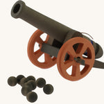 the 10 wooden cannon balls from the Ostheimer Large Cannon set with the cannon in the background pictured on a plain background