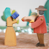 Ostheimer farmer man and Noah's wife wooden toy figures, handmade in Germany and exchanging a small gift and brown rooster in a waldorf and small world play scene, sold at Babipur