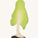 Ostheimer Large Wooden Birch Tree, handmade and hand crafted with a light green painted top to represent leaves, and painted bark and trunk detail. The tree is on a cream background.