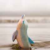 A close up of the Ostheimer wooden dolphin figure with its head held high coming out out water showing the hand painted detail.