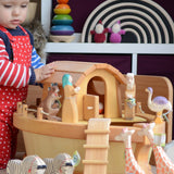 A child playing with the handmade wooden Ostheimer Noah's ark and ship's cabin with hand-painted animals and figures.