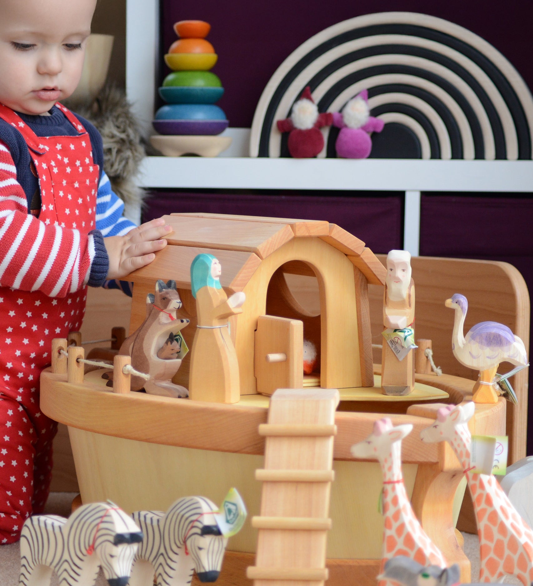 A child playing with the handmade wooden Ostheimer Noah's ark and ship's cabin with hand-painted animals and figures.
