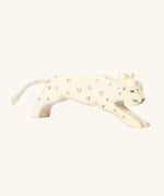 A beautifully hand crafted and hand painted Snow Leopard toy, in white with grey spots, blue eyes and a cord tail