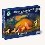 A closed navy cardboard box with a photo of the Ostheimer nativity and diorama set on the front on a cream background