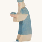A Ostheimer wooden king figure wearing a blue gown and a blue crown on his head on a cream background.
