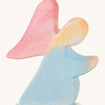 A blue kneeling Ostheimer wooden angel figure with red wings on a cream background.