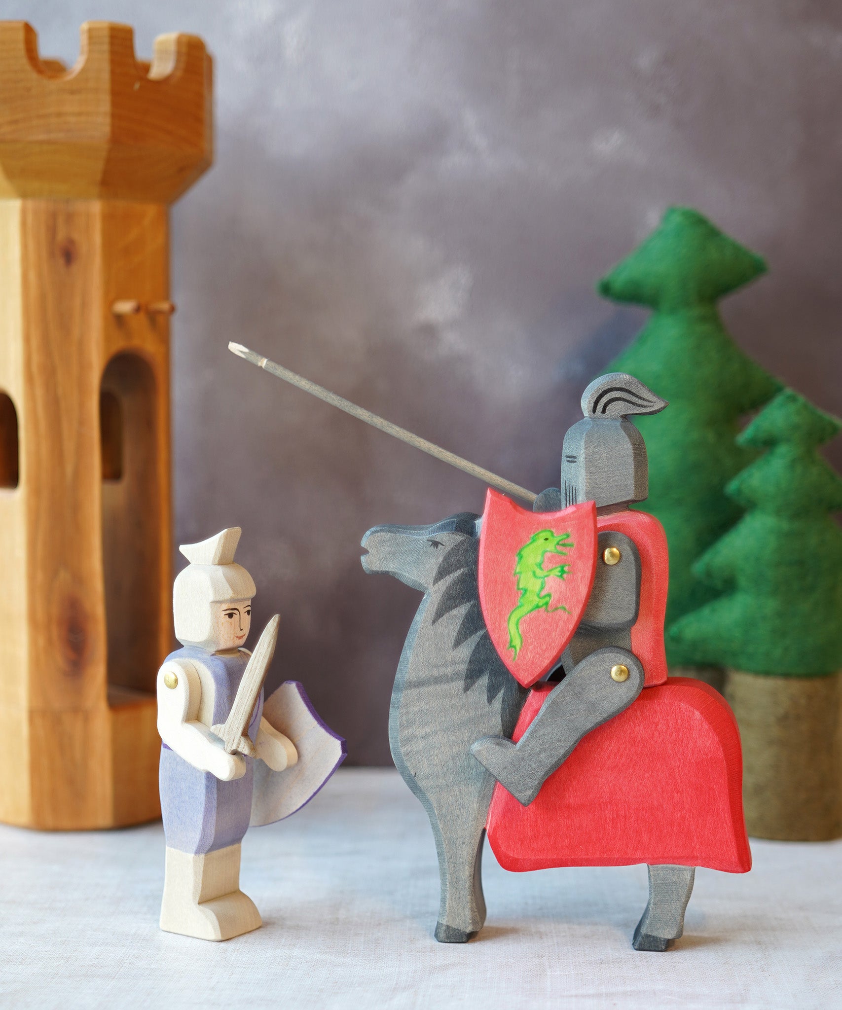 The Ostheimer handmade from Germany Wooden Blue Standing Knight Figure standing next to the Black Knight and Horse set deal for a fantasy world storytelling and open-ended play, sold at Babipur