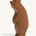 A wooden Ostheimer large brown bear standing with its head high on a cream background.