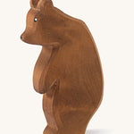  A wooden Ostheimer large brown bear standing on a cream background.