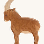 A brown wooden Ostheimer mountain goat on a cream background.