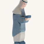 A oriental wooden Ostheimer king figure wearing a blue gown on a cream background.