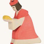 A Ostheimer wooden king figure wearing a red gown and a red crown on his head on a cream background.