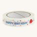 Happy birthday paper tape on a cream background.