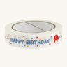 Happy birthday paper tape on a cream background.