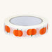 Babipur Pumpkin Eco Paper Tape in white, with orange pumpkin repeat pattern. On a cream background