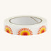 Paper tape with sunshine design on cream background.