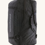 The Patagonia Black Hole Duffel 100L Black upright showing the shoulder straps and carry handles