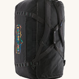 The Patagonia Black Hole Duffel 100L Ink Black upright showing the shoulder straps and carry handle