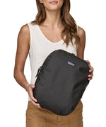A person holding a Patagonia Black Hole Cube 14L Black in their hands
