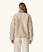 Back of woman wearing Patagonia Women's Classic Retro-X® Fleece Jacket in Dark Natural w/River Rock Green.
