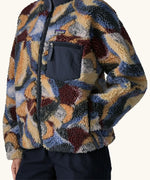 Close up of Woman wearing Patagonia Women's Classic Retro-X® Fleece Jacket in Smudge, Smolder Blue. Hand in pocket. 