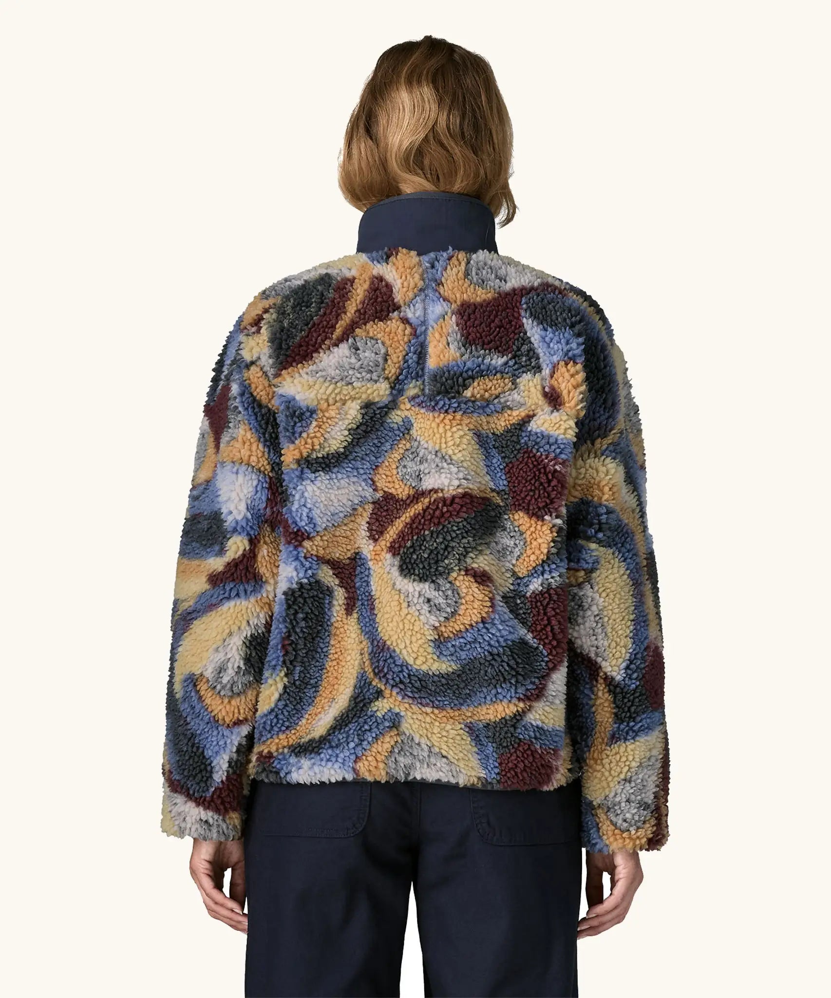 Back of Woman wearing Patagonia Women's Classic Retro-X® Fleece Jacket in Smudge, Smolder Blue. The Blue, cream, green and brown smudge pattern visible.