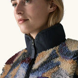 Close up of collar, zip and patch stitched Patagonia logo on Patagonia Women's Classic Retro-X® Fleece Jacket in Smudge, Smolder Blue, worn by a woman.