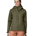A person wearing the Patagonia Women's Torrentshell 3L Rain Jacket - Pine Needle Green, to show the fit of the jacket from the front.