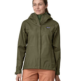 A person wearing the Patagonia Women's Torrentshell 3L Rain Jacket - Pine Needle Green, to show the fit of the jacket from the front.
