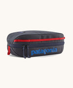 Patagonia 3L black hole cube travel bag in smolder blue/ amanita red available at Babpipur. A dark blue travel bag with a zip fastener with the brand name on the top panel