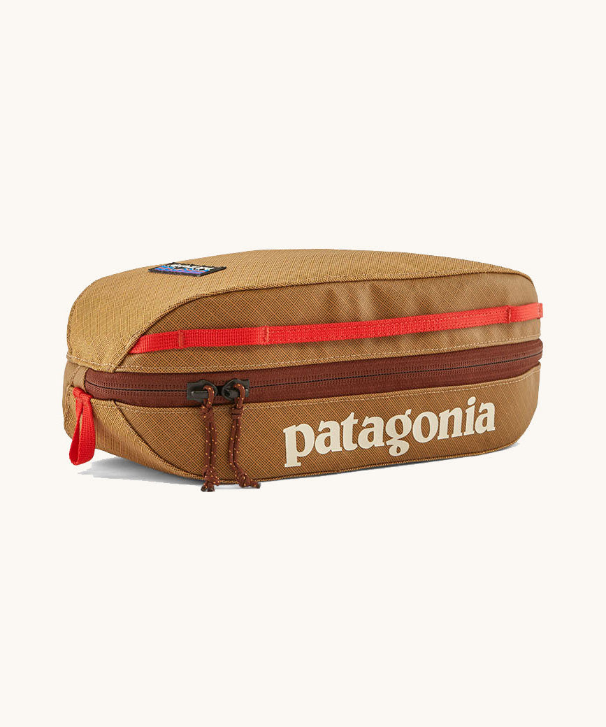 Patagonia 3L black hole cube travel bag in talon hold available at Babpipur. A dark orange travel bag with a brown zip fastener and the brand name on the top panel