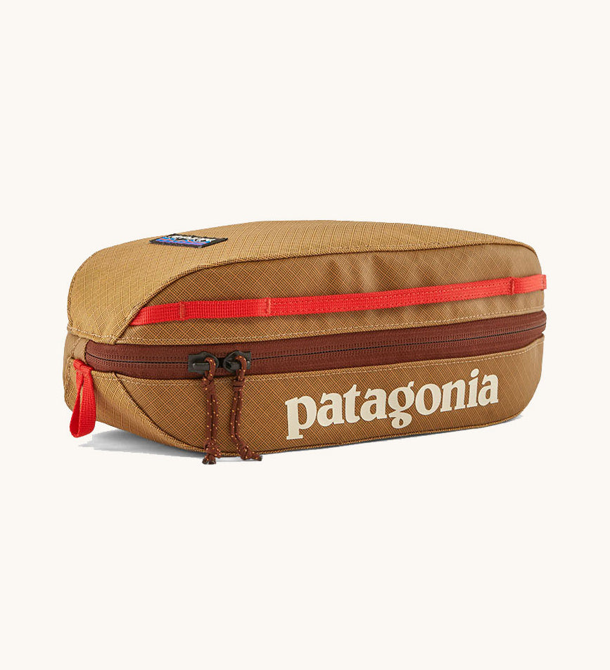 Patagonia 3L black hole cube travel bag in talon hold available at Babpipur. A dark orange travel bag with a brown zip fastener and the brand name on the top panel