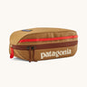 Patagonia 3L black hole cube travel bag in talon hold available at Babpipur. A dark orange travel bag with a brown zip fastener and the brand name on the top panel