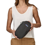 A person holding a Patagonia Black Hole Cube 3L in their hands