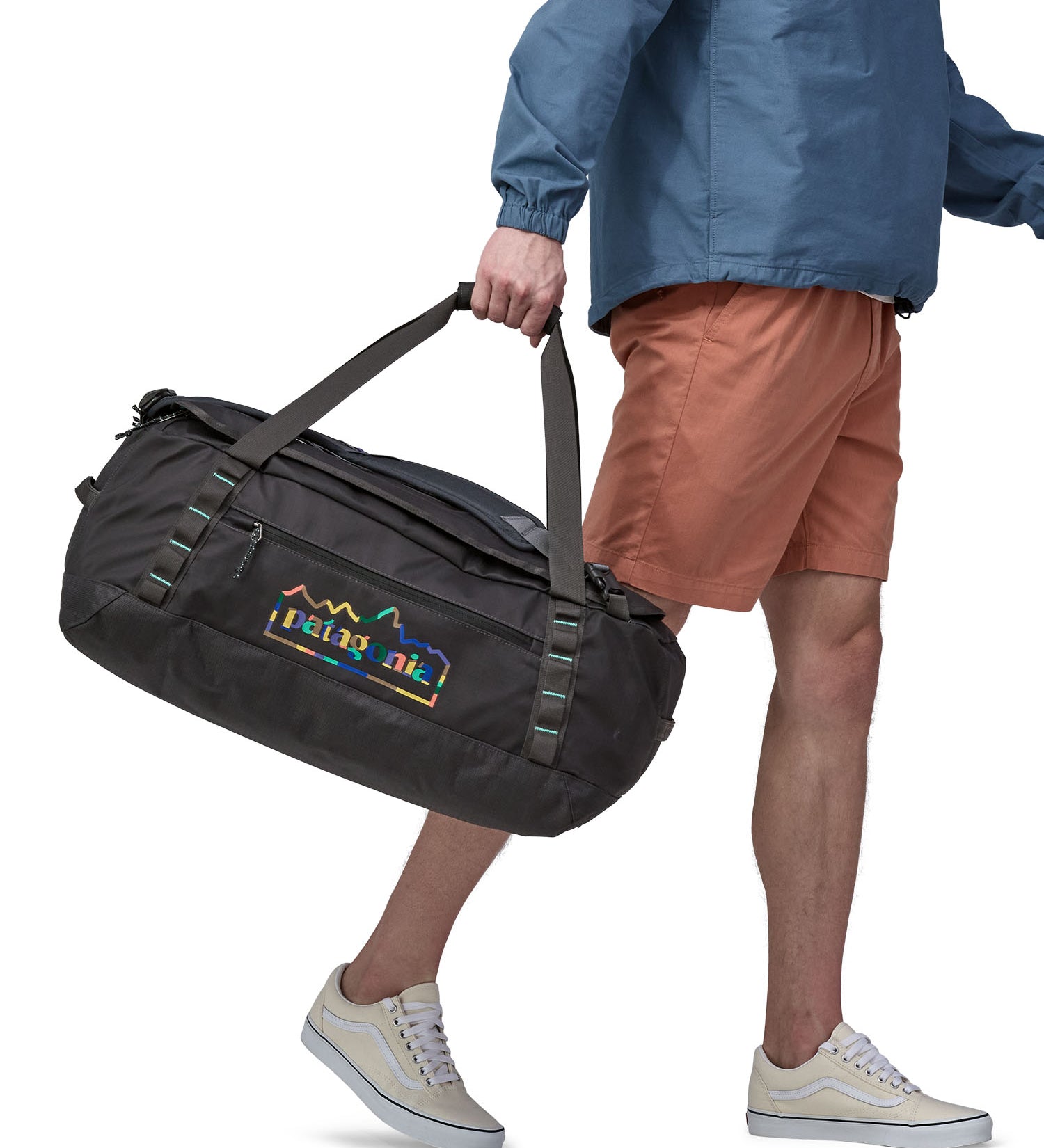 A person carrying the Patagonia Black Hole Duffel 55L in their hands using the carry straps