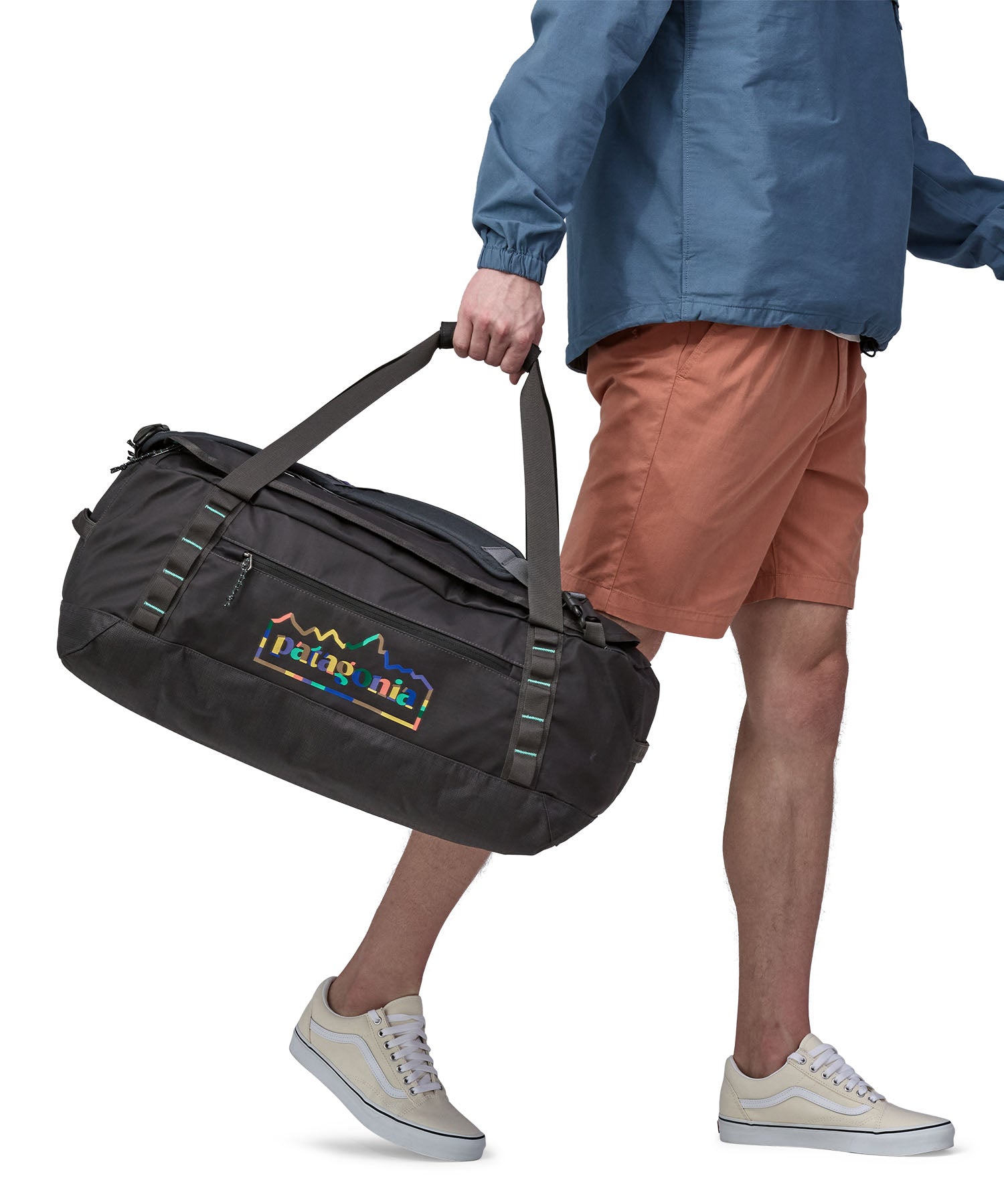 A person carrying the Patagonia Black Hole Duffel 55L in their hands using the carry straps