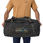 A person holding the Patagonia Black Hole Duffel 70L Ink Black in their hands to show the size