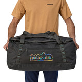A person holding the Patagonia Black Hole Duffel 70L Ink Black in their hands to show the size