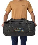 A person holding the Patagonia Black Hole Duffel 70L Ink Black in their hands to show the size