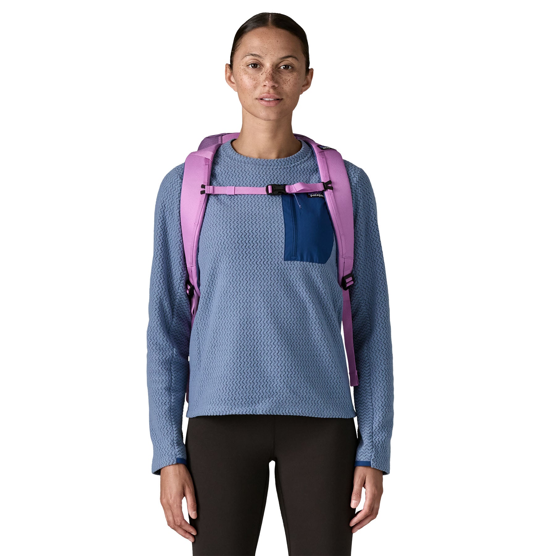 A woman wearing the Patagonia black hole 25 litre backpack in brisk purple available at Babipur 