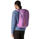 The back of a woman wearing the The back of the Patagonia black hole 25 litre backpack in brisk purple available at Babipur.