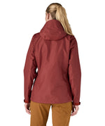 The back of the Patagonia Women's Torrentshell 3L Rain Jacket - Oxide Red. The image shows a person wearing the jacket to show the fit of the coat from the back and the hood